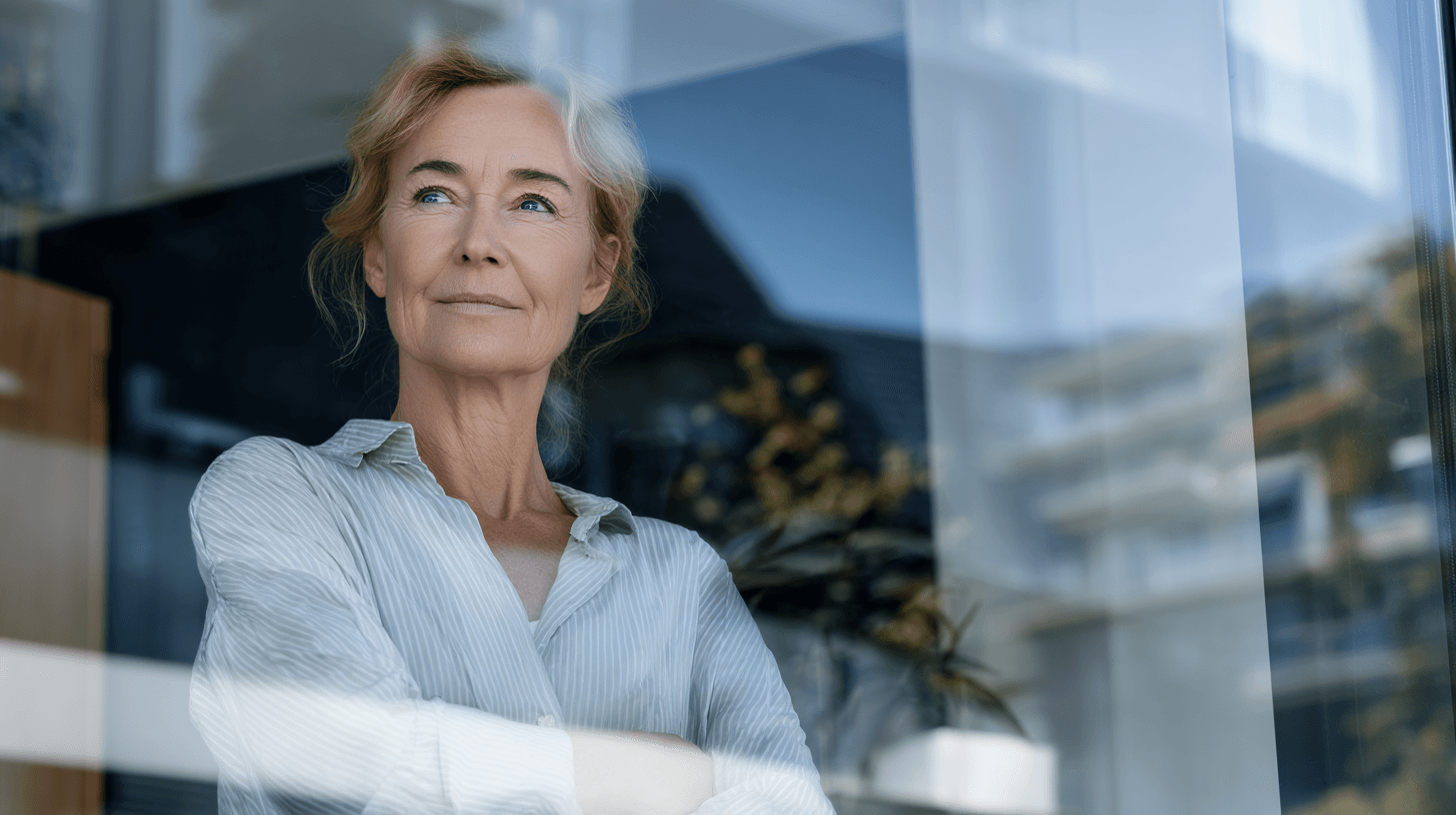 Frau hinter spiegelnder Fensterscheibe.